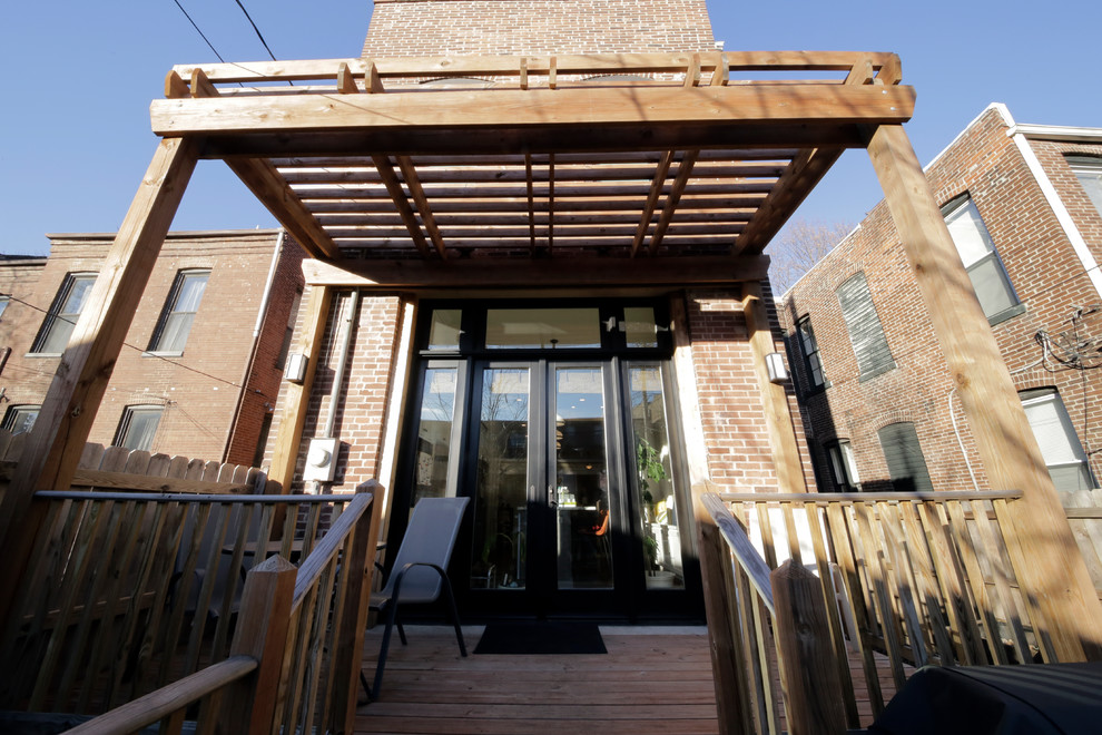 Photo of a medium sized bohemian back patio in St Louis with brick paving and an awning.