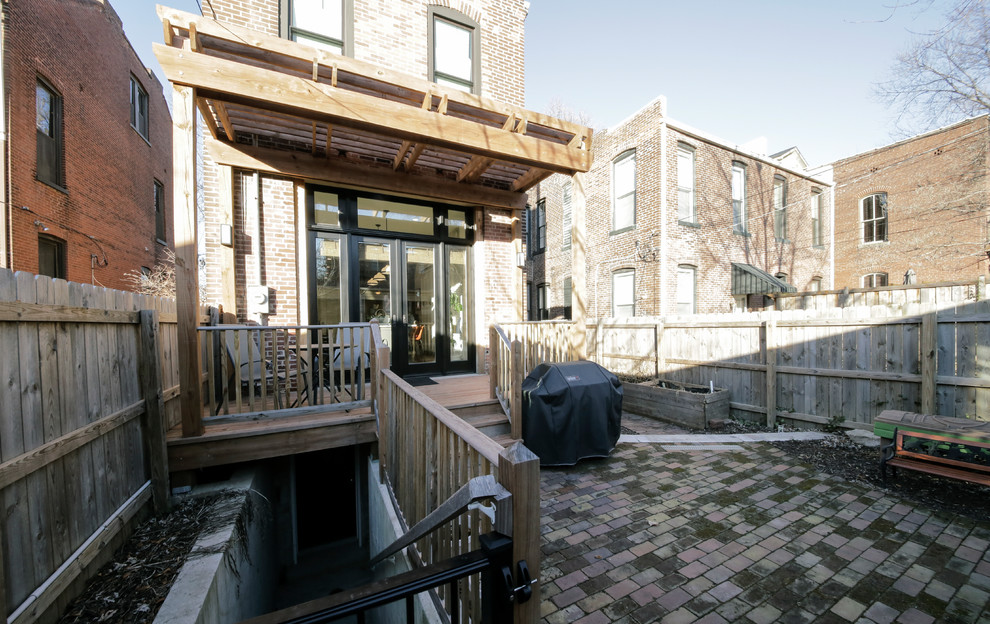 Design ideas for a medium sized bohemian back patio in St Louis with brick paving and an awning.