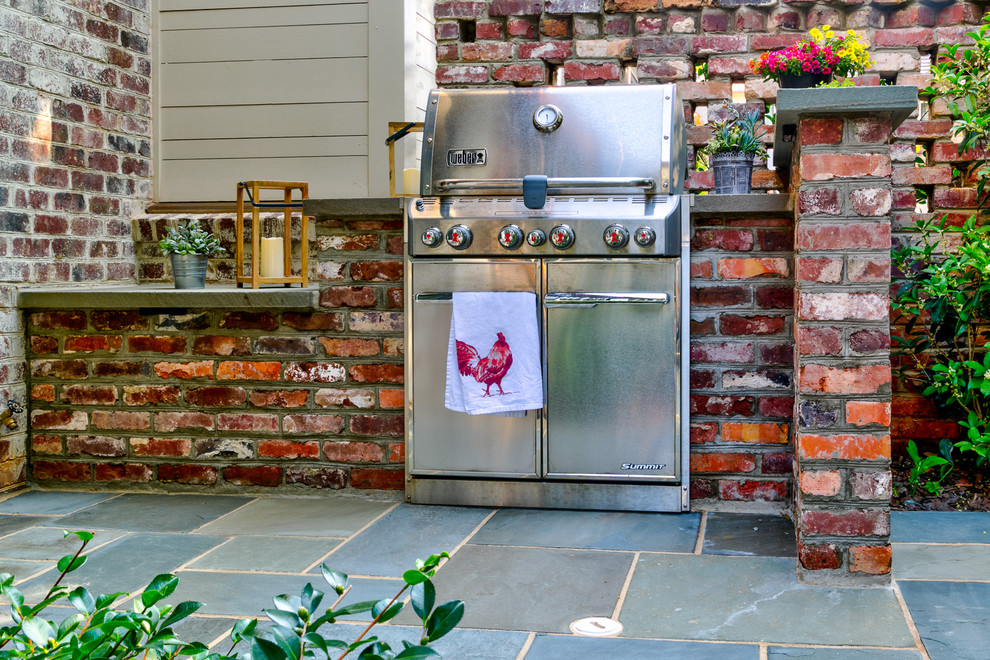 Small classic courtyard patio in Charlotte with an outdoor kitchen, natural stone paving and no cover.