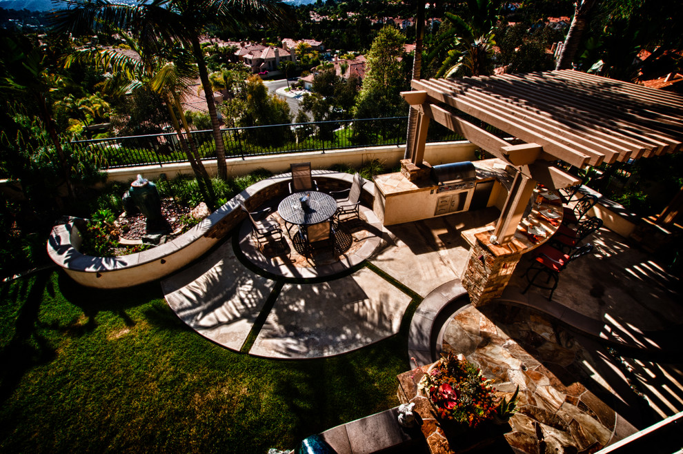 Inspiration pour une terrasse arrière méditerranéenne de taille moyenne avec une cuisine d'été, une dalle de béton et une pergola.