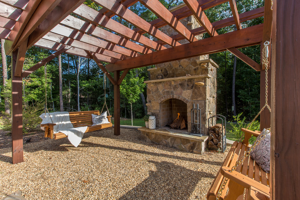 Inspiration for a medium sized rustic back patio in Charlotte with a fire feature, gravel and a pergola.