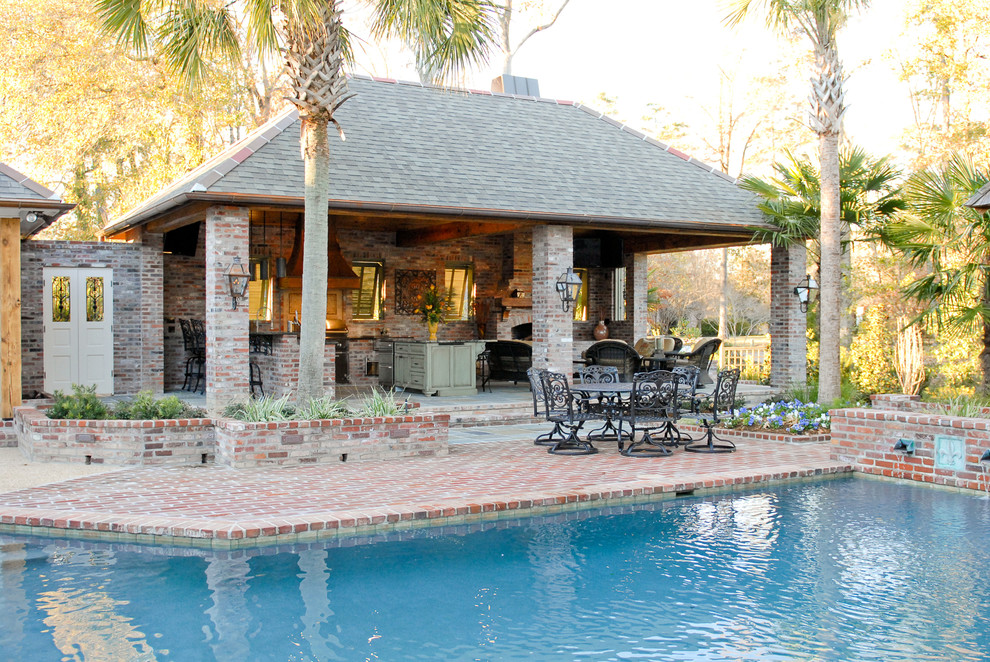 This is an example of a large mediterranean back patio in New Orleans with an outdoor kitchen, brick paving and a gazebo.