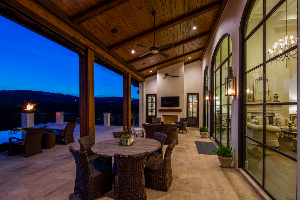 Immagine di un grande patio o portico mediterraneo dietro casa con un focolare e un tetto a sbalzo