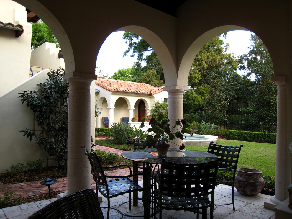Пример оригинального дизайна: двор среднего размера на заднем дворе в средиземноморском стиле с фонтаном, покрытием из каменной брусчатки и навесом