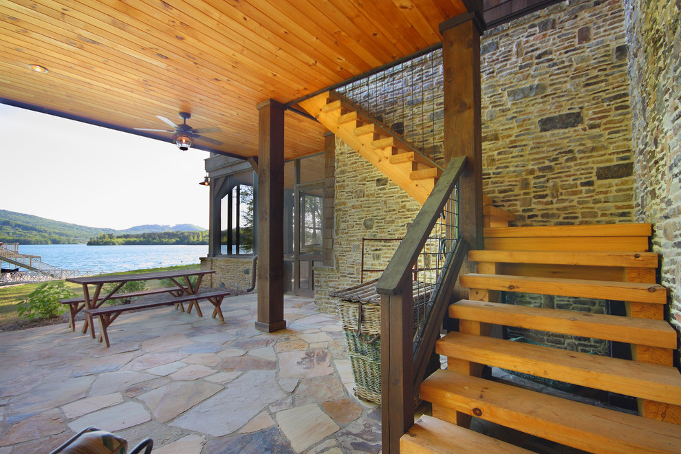 Réalisation d'une terrasse chalet avec des pavés en pierre naturelle et une extension de toiture.
