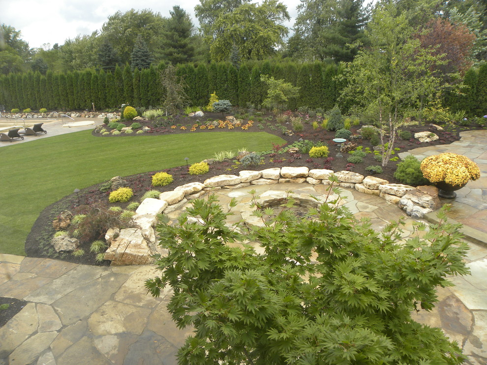 Пример оригинального дизайна: огромный двор на заднем дворе в классическом стиле с фонтаном и покрытием из каменной брусчатки