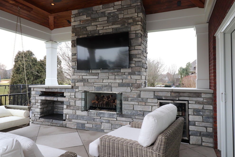 Design ideas for a large classic back patio in Louisville with a fireplace, concrete paving and a roof extension.