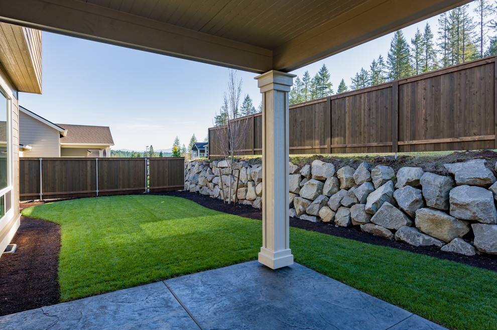 Foto de patio clásico de tamaño medio sin cubierta en patio trasero con losas de hormigón