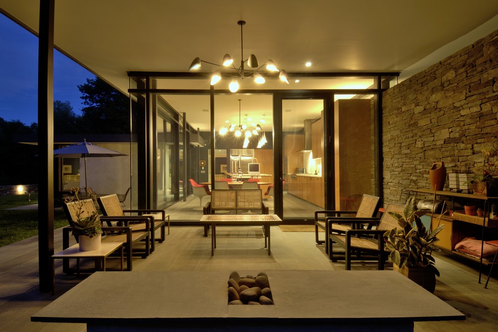Medium sized contemporary back patio in New York with stamped concrete and a roof extension.