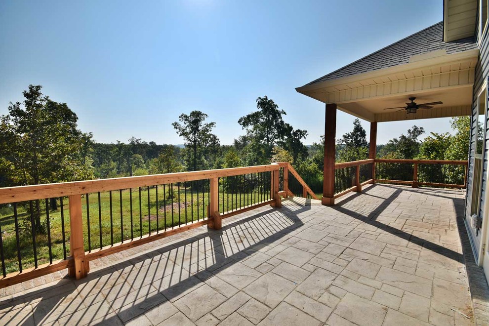 Inspiration for a large craftsman backyard stamped concrete patio remodel in Little Rock with a roof extension