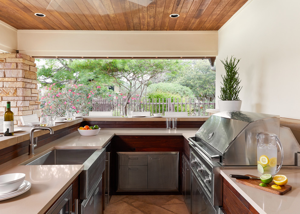 Inspiration pour une terrasse arrière traditionnelle de taille moyenne avec une cuisine d'été, une extension de toiture et des pavés en pierre naturelle.