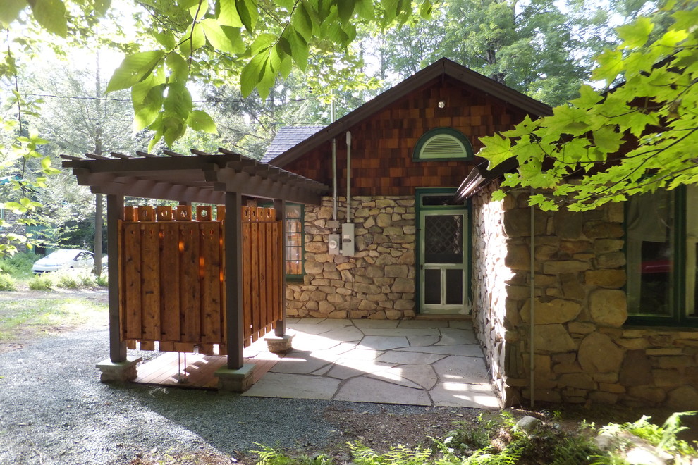 Imagen de patio de estilo americano pequeño en patio lateral con ducha exterior, adoquines de piedra natural y pérgola