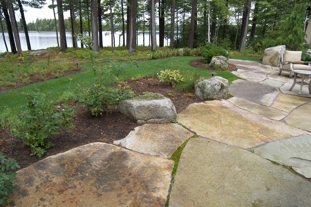 Cette image montre une terrasse arrière chalet de taille moyenne avec des pavés en pierre naturelle et aucune couverture.