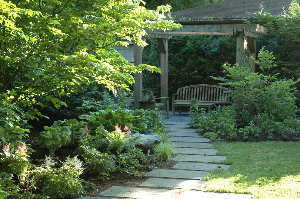Foto di un patio o portico american style di medie dimensioni e dietro casa con pavimentazioni in pietra naturale e una pergola