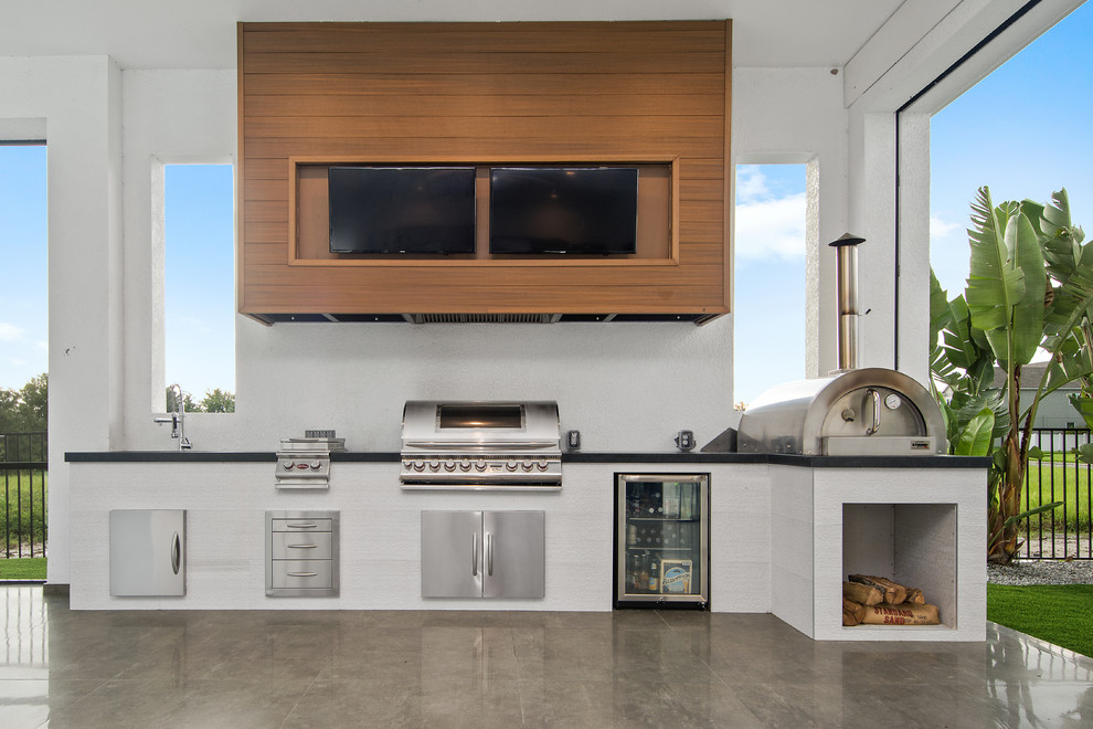 Стильный дизайн: двор в современном стиле с летней кухней, покрытием из бетонных плит и навесом - последний тренд