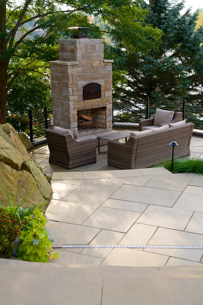Immagine di un grande patio o portico tradizionale con un caminetto e pavimentazioni in pietra naturale