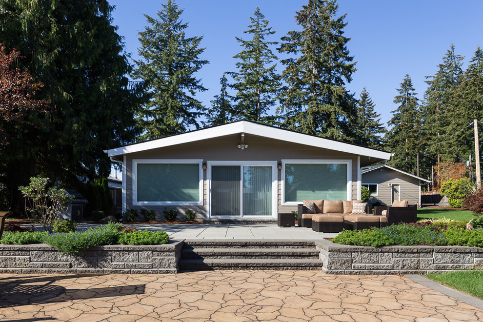 This is an example of a large traditional back patio in Seattle with a fire feature, concrete paving and no cover.