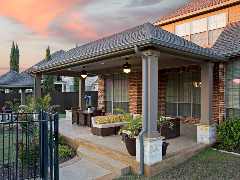 Ispirazione per un patio o portico contemporaneo dietro casa e di medie dimensioni con cemento stampato e un tetto a sbalzo