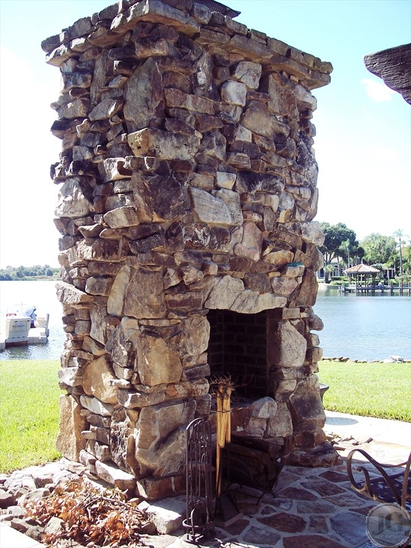 Inspiration for a large timeless backyard stone patio remodel in Tampa with a gazebo and a fire pit