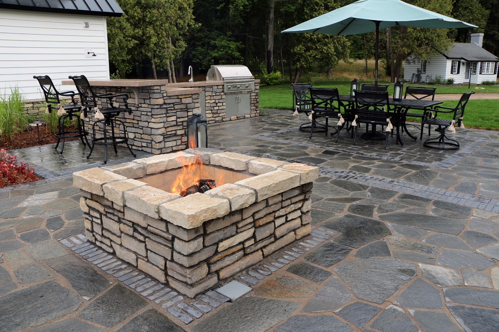 Diseño de patio de estilo americano grande en patio lateral con adoquines de piedra natural y cocina exterior