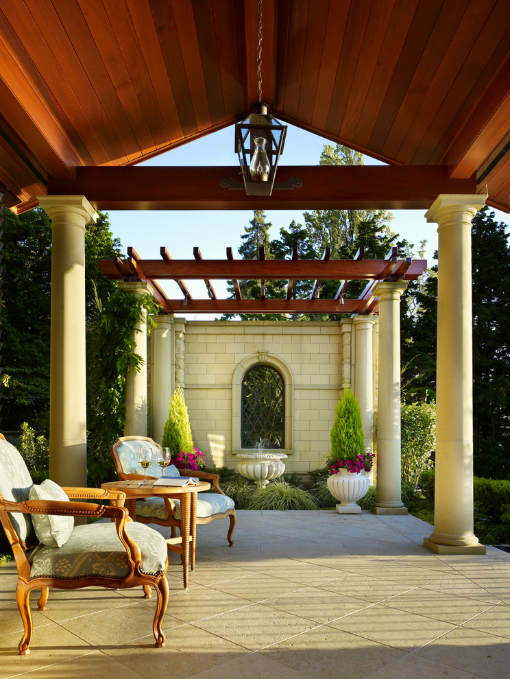 Foto di un ampio patio o portico mediterraneo dietro casa con un giardino in vaso, pavimentazioni in cemento e un tetto a sbalzo