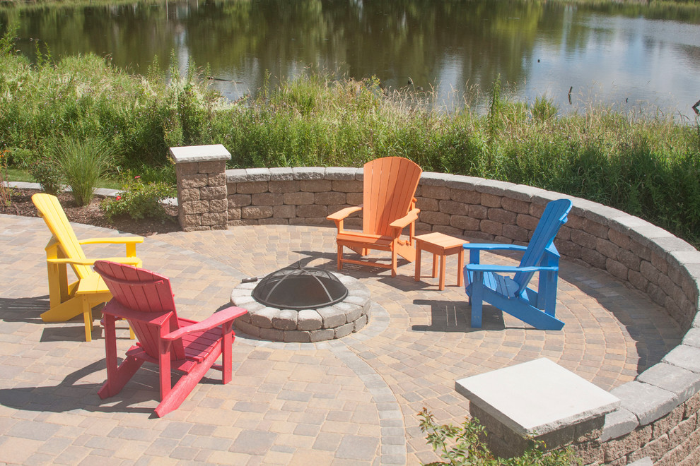 Inspiration for a mid-sized timeless backyard concrete paver patio remodel in Minneapolis with a fire pit and a roof extension