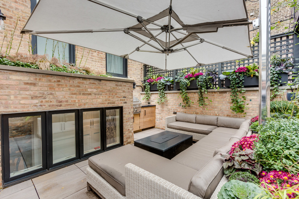 Classic back patio in Chicago with an outdoor kitchen and an awning.