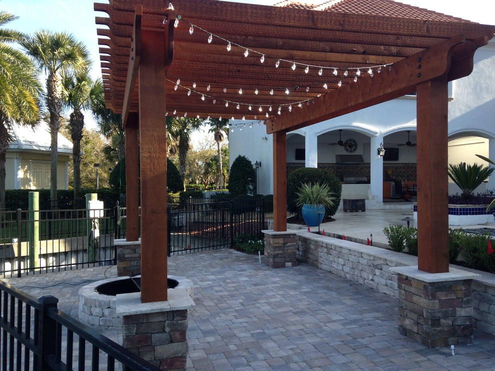 Mid-sized elegant backyard brick patio photo in Jacksonville with a fire pit and a pergola