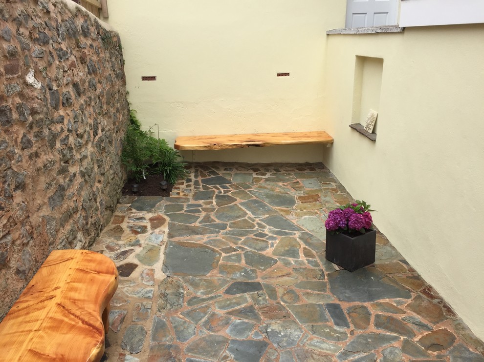 Immagine di un piccolo patio o portico moderno in cortile con pavimentazioni in pietra naturale e nessuna copertura