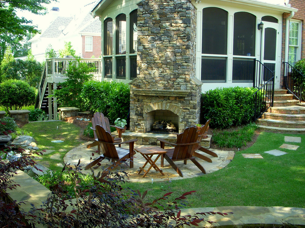 Diseño de patio clásico con chimenea y todos los revestimientos
