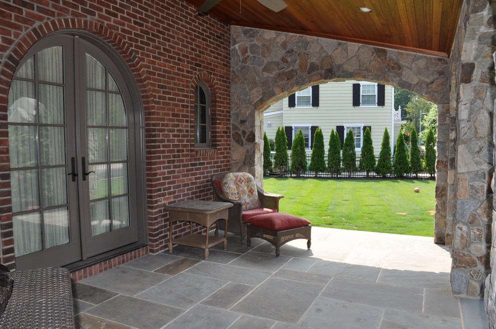 Photo of a medium sized classic front patio in New York with a roof extension.