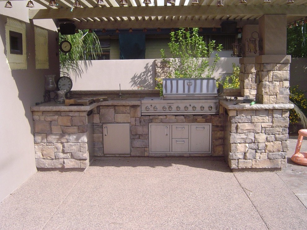 Cette image montre une petite terrasse arrière traditionnelle avec une cuisine d'été, un auvent et un gravier de granite.