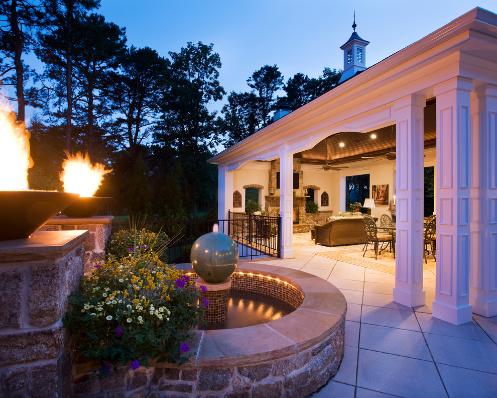 Foto di un patio o portico classico di medie dimensioni e dietro casa con un focolare e una pergola
