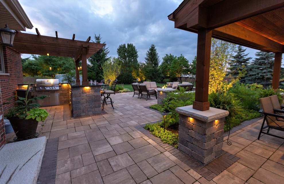 Ejemplo de patio actual de tamaño medio en patio trasero con adoquines de piedra natural