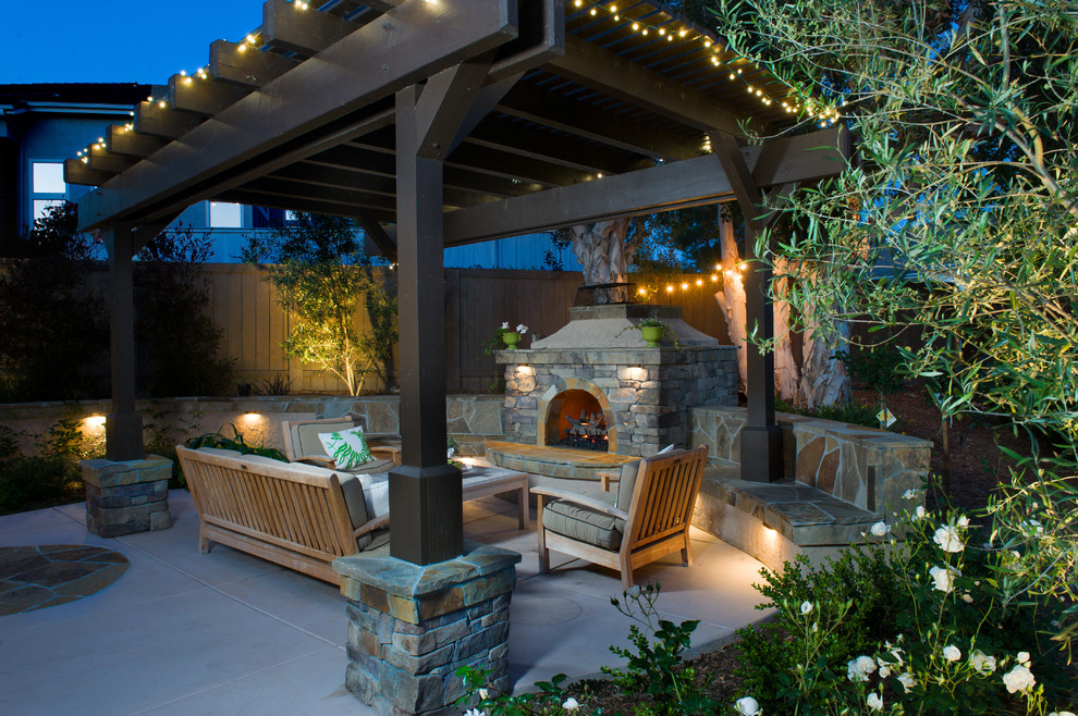 Photo of a medium sized rustic back patio in San Diego with a fire feature, stamped concrete and a pergola.