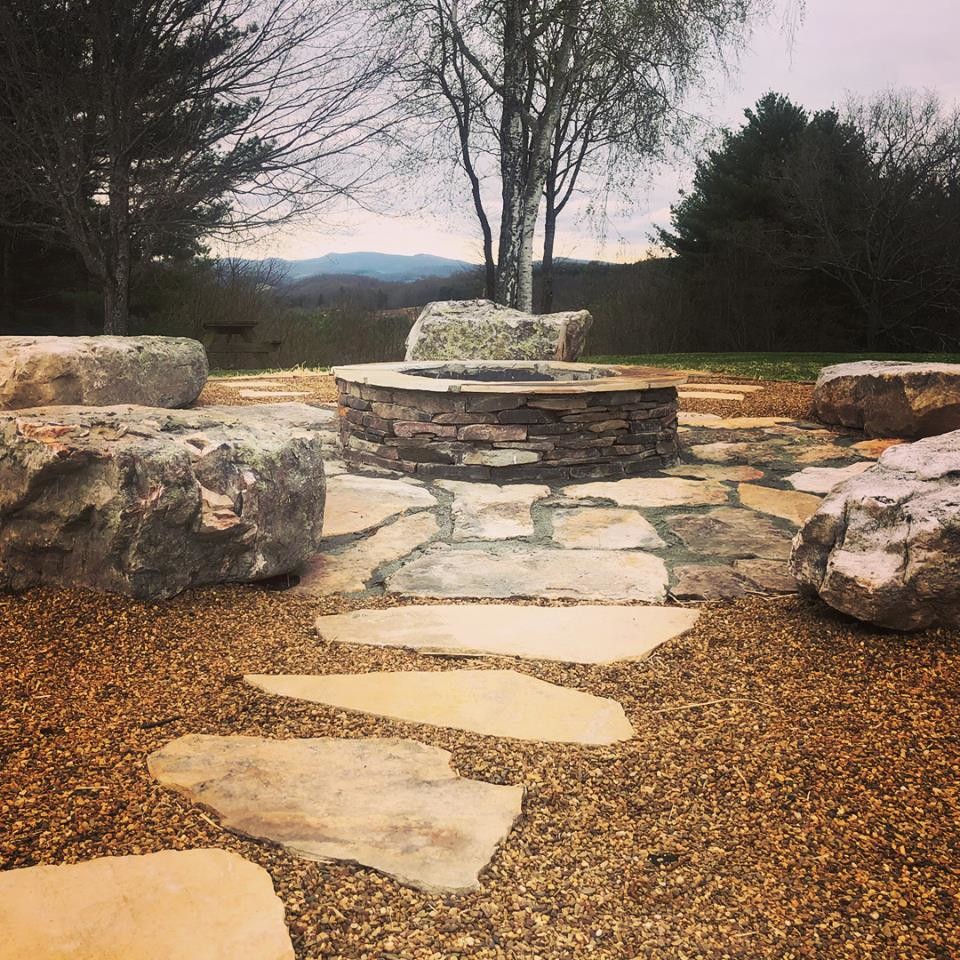 Mid-sized elegant backyard stone patio photo in Charlotte with a fire pit and no cover