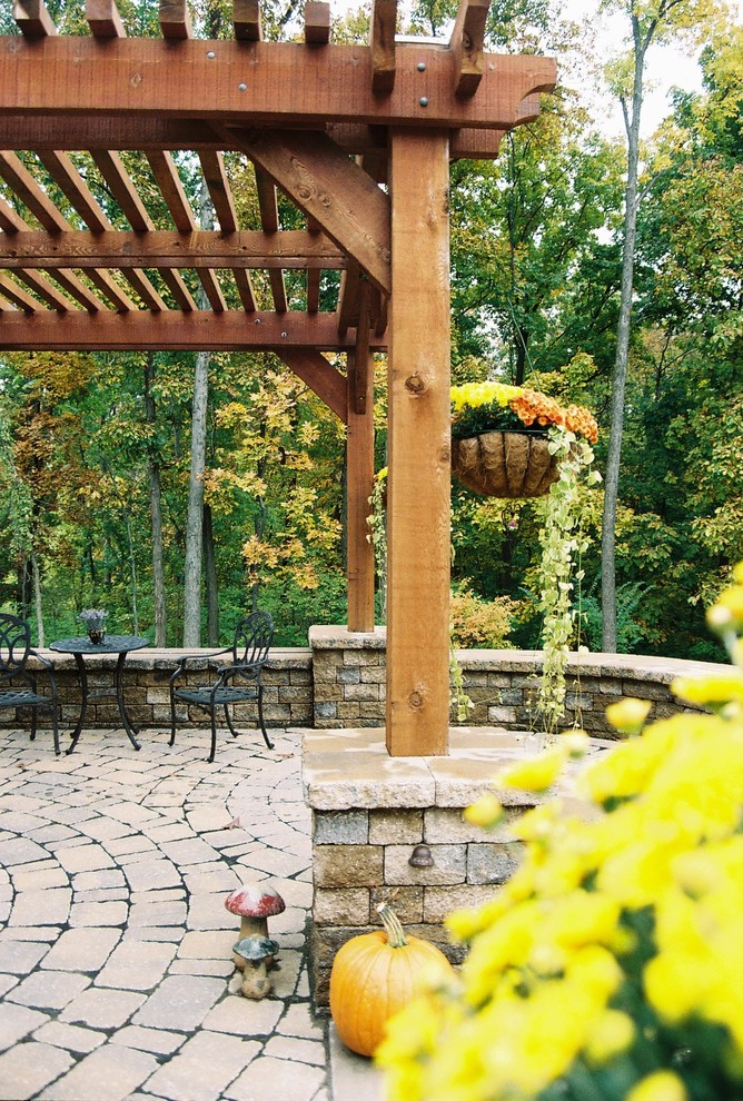 Foto de patio clásico de tamaño medio en patio trasero con adoquines de hormigón y pérgola
