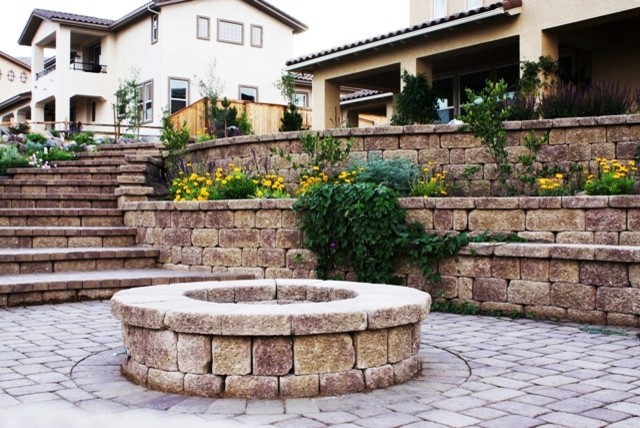 Diseño de patio mediterráneo de tamaño medio sin cubierta en patio trasero con brasero y adoquines de hormigón