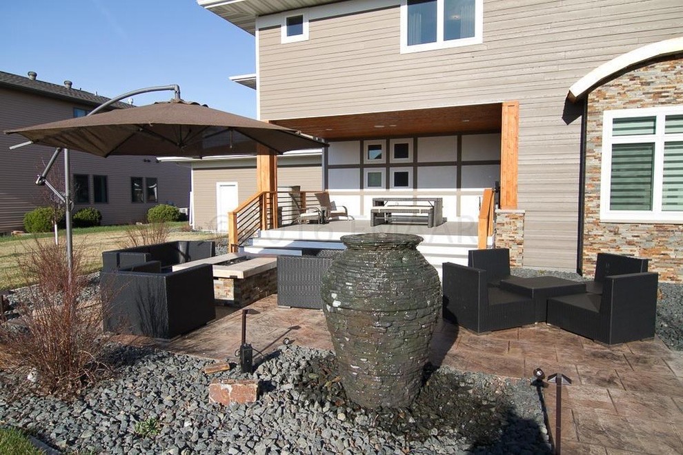 Large trendy backyard stamped concrete patio fountain photo in Minneapolis with no cover
