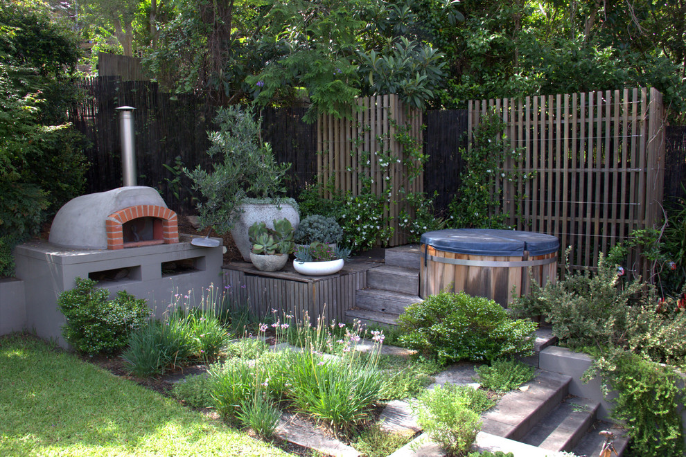 Immagine di un patio o portico minimal dietro casa con un caminetto e nessuna copertura