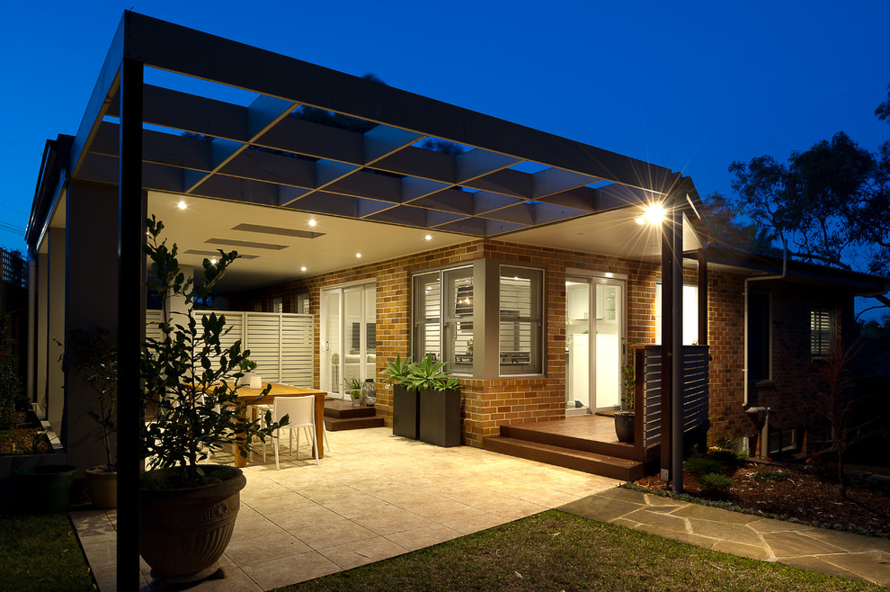 Стильный дизайн: большой двор на заднем дворе в современном стиле с покрытием из плитки и навесом - последний тренд