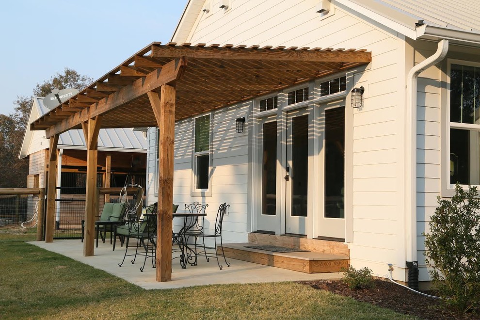 Immagine di un patio o portico classico di medie dimensioni e dietro casa con pavimentazioni in cemento e una pergola