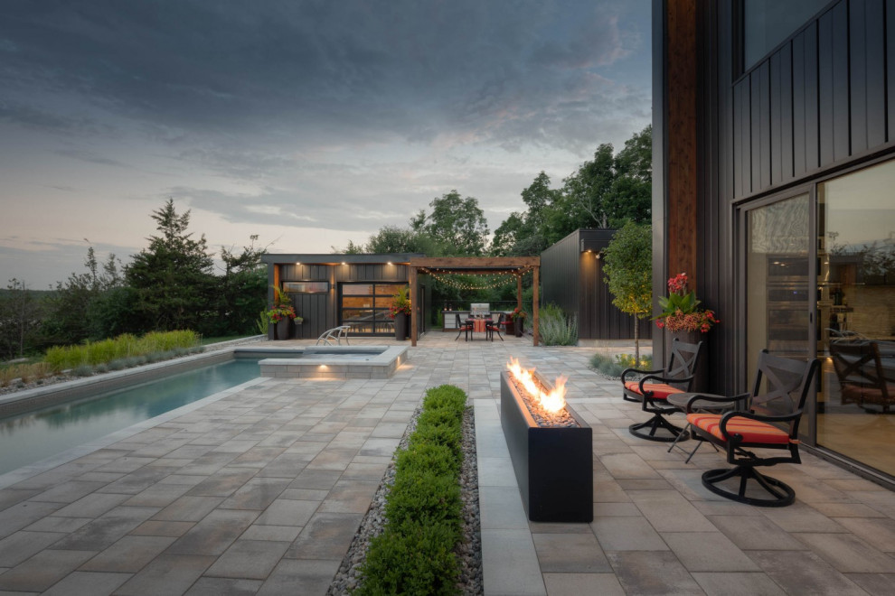 Ispirazione per un grande patio o portico minimalista dietro casa con un caminetto, pavimentazioni in pietra naturale e una pergola