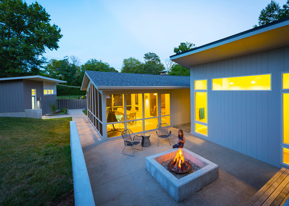 Ispirazione per un patio o portico minimalista di medie dimensioni e dietro casa con un focolare, lastre di cemento e nessuna copertura
