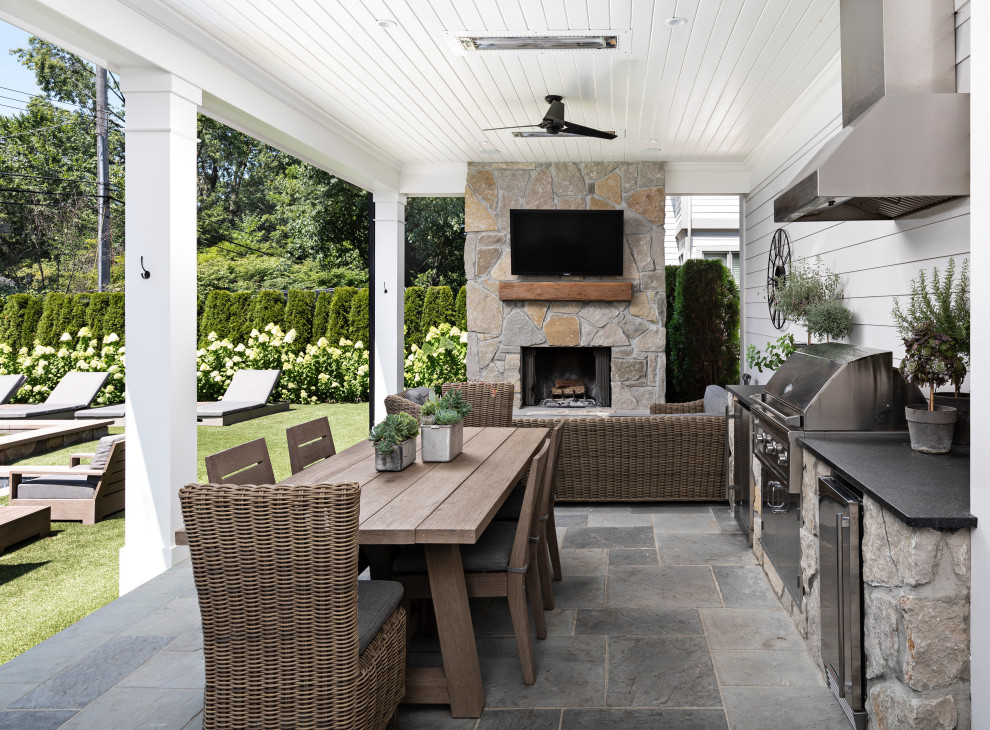 На фото: двор среднего размера на заднем дворе в стиле кантри с покрытием из каменной брусчатки, навесом и зоной барбекю