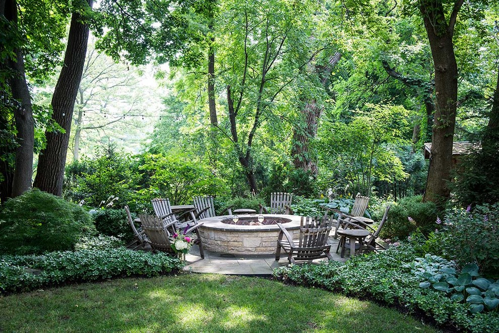 Large fire pit set into woodland with lush plantings - Rustic - Patio