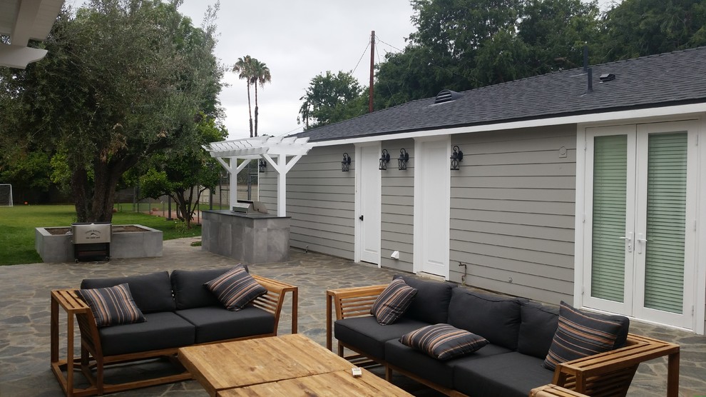 Großer, Unbedeckter Klassischer Patio hinter dem Haus mit Outdoor-Küche und Natursteinplatten in Los Angeles
