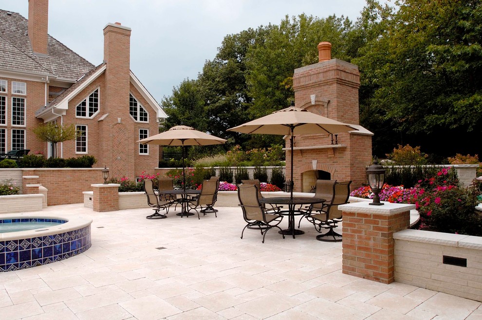 Expansive traditional back patio in Chicago with natural stone paving.