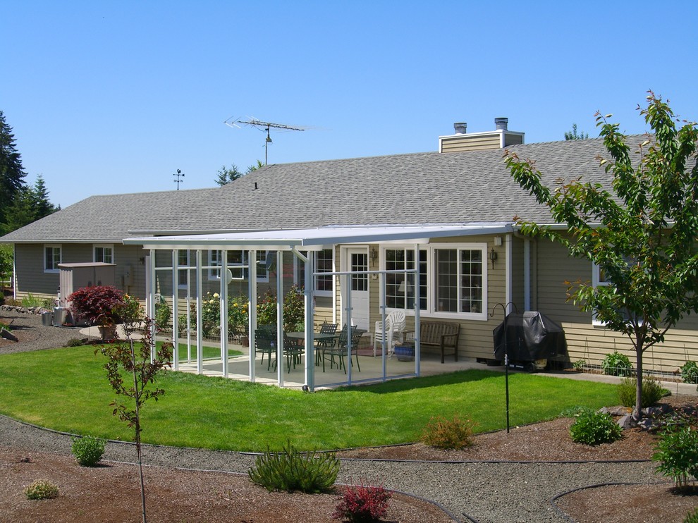 Diseño de patio campestre de tamaño medio en patio trasero con losas de hormigón y toldo