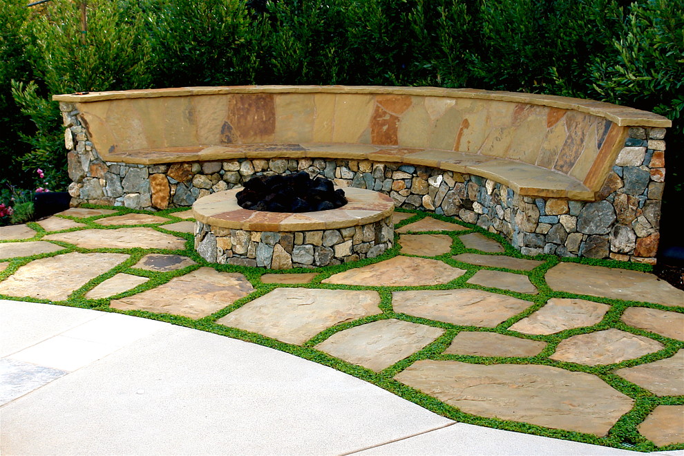 This is an example of a mediterranean patio in San Diego with a fire feature and natural stone paving.